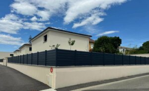 Clôture moderne en pvc plaxé gris anthracite fixée sur un muret extérieur