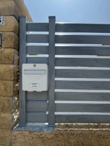 Clôture extérieure modèle Cerbère en PVC gris, posée sur muret idéale pour délimiter un espace avec élégance et discrétion.