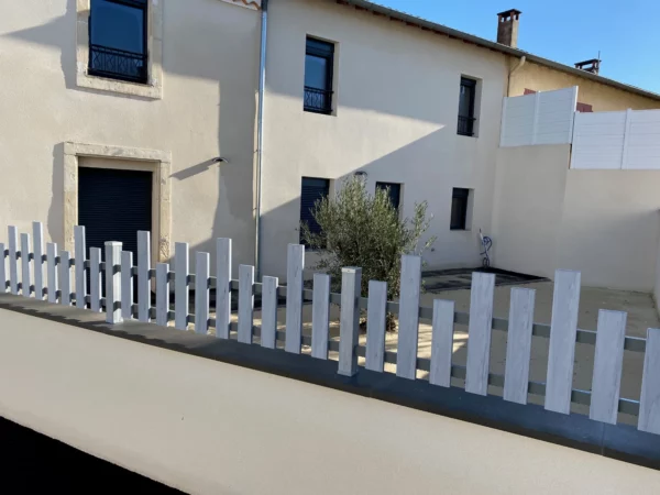 clôture gris cérusé posée sur un muret enduit avec des couvertines aluminium dans le cadre d'une rénovation totale de maison