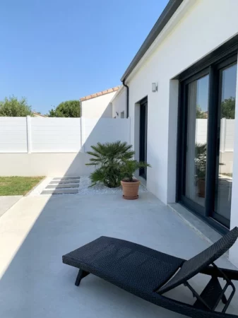 clôture pleine blanche entre voisins, dans un environnement moderne