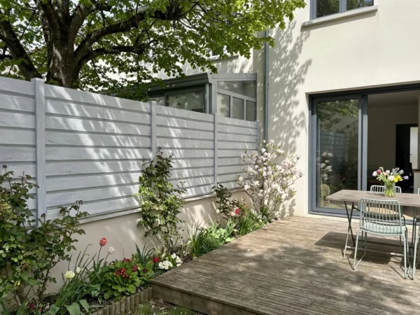 clôture en pvc gris clair dans un petit jardin ombragé