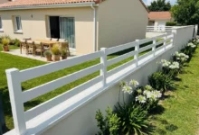 clôture blanche en PVC sur un muret dans un jardin fleuri