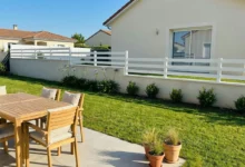 clôture blanche très ajourée posée sur un muret en redans dans un lotissement