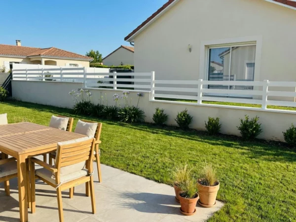 clôture blanche très ajourée posée sur un muret en redans dans un lotissement