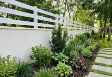 clôture ajourée de style ranch posée sur un muret dans un grand jardin arboré