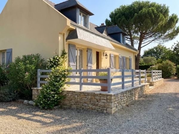 clôture très ajourée en pvc gris clair sur la terrasse d'une maison colorée