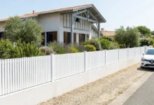 clôture à barreaux en PVC blanc, installée dans le jardin d’une résidence en bord de mer.