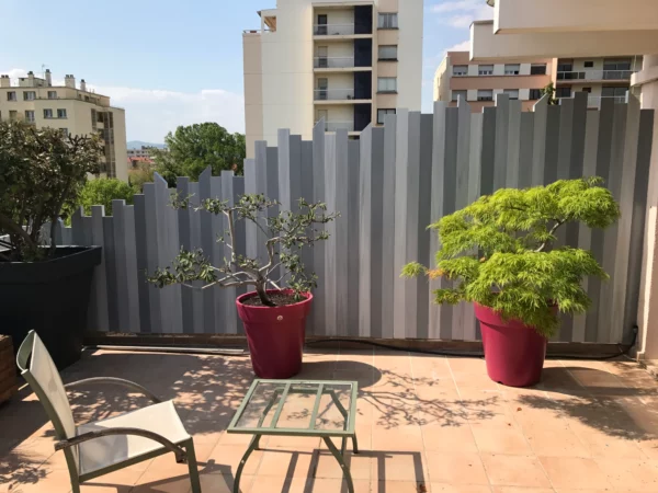Clôture brise-vue sur terrasse, modèle Sirus gris à lames verticales de hauteurs variées