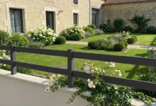 clôture ajournée moderne posée sur un muret autour d'une maison en pierres
