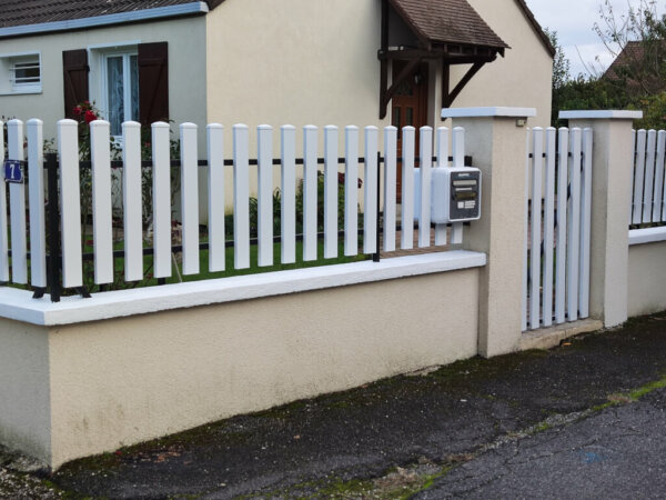 Rénovation d'une clôture sur muret avec les lames pvc blanc de 100 mm de large et 20 mm de hauteur en intégrant la boîte aux lettres