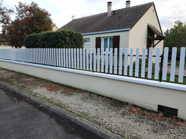 Rénovation d'une clôture sur muret avec les lames pvc blanc de 100 mm de large et 20 mm de hauteur avec des chapeaux en pointe diamant