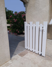 Portillon en pvc blanc ajouré avec une coupe irrégulière pour chacune des lames verticales