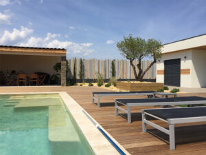 Clôture en pvc multicolore brise-vue originale installée en bord de piscine pour apporter une touche de modernité à votre extérieur