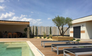 Clôture en pvc multicolore brise-vue originale installée en bord de piscine pour apporter une touche de modernité à votre extérieur
