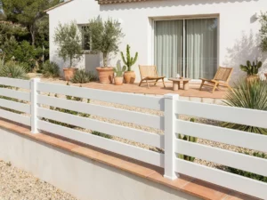 barrière ajourée posée sur une murette avec des couvertines en terre cuites dans un jardin à l'esprit méditerranéen