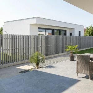Clôture droite à lames verticales installée sur un soubassement en béton autour d'une villa contemporaine