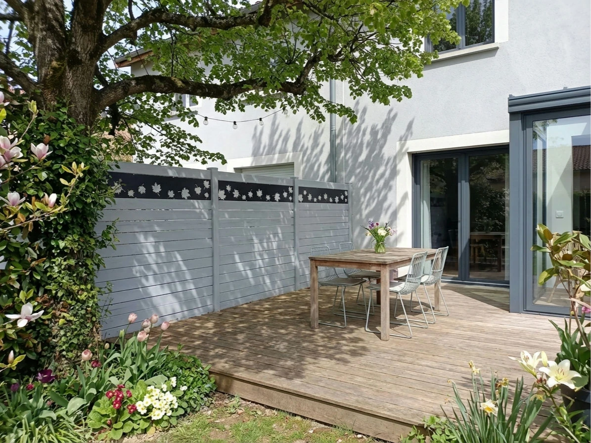 clôture imprimée feuilles sur fond gris anthracite autour d'une terrasse