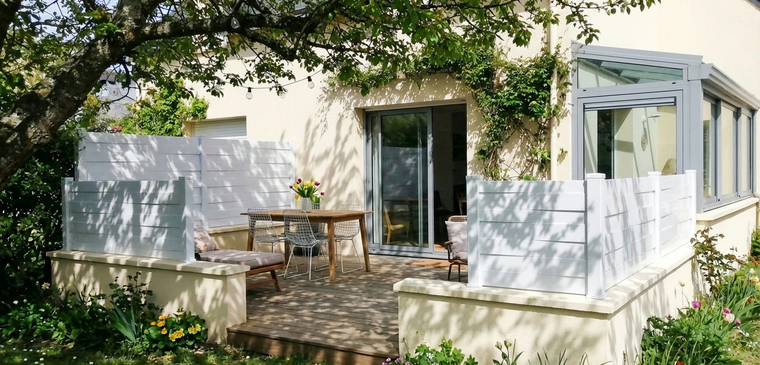 clôture blanche originale posée sur une murette enduit autour d'un terrasse en bois