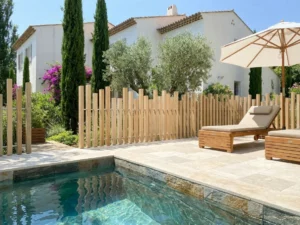 clôture effet bois installée sur une terrasse en carrelage travertin autour d'une piscine