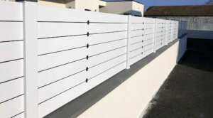 Clôture en pvc blanc brise-vue installée sur muret idéal pour maison moderne et apporter une touche d'originalité à votre extérieur