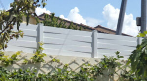 Clôture en pvc blanc brise-vue installée sur muret