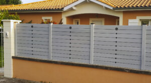 Clôture en pvc gris brise-vue installée sur muret idéal pour maison de lotissement et apporter une touche d'originalité à votre extérieur