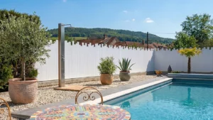 clôture brise vue en pvc blanc coupe irrégulière installée autour d'une piscine