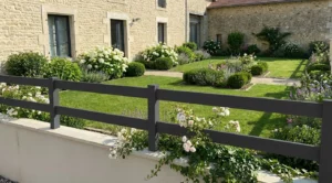 clôture ajournée moderne posée sur un muret autour d'une maison en pierres